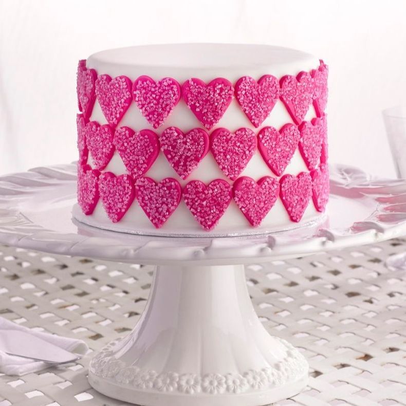 White cake with pink fondant hearts by cake angels